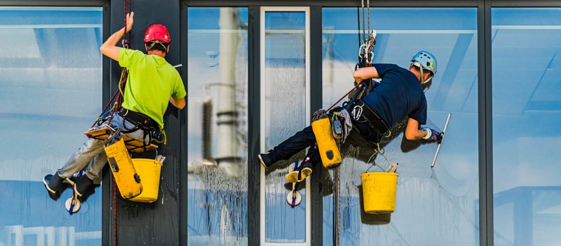 Two men cleaning windows on an office building